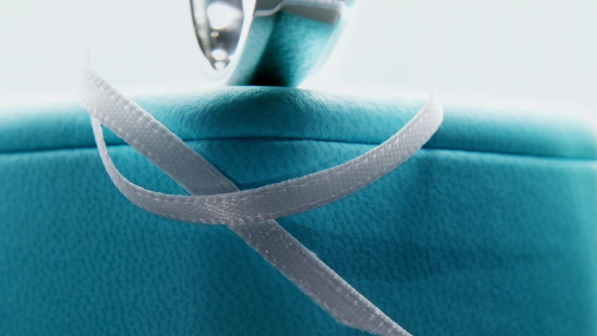 Close-up of the iconic Tiffany blue box with a white satin ribbon, symbolizing luxury and the timeless elegance of Tiffany & Co.'s fine jewelry.