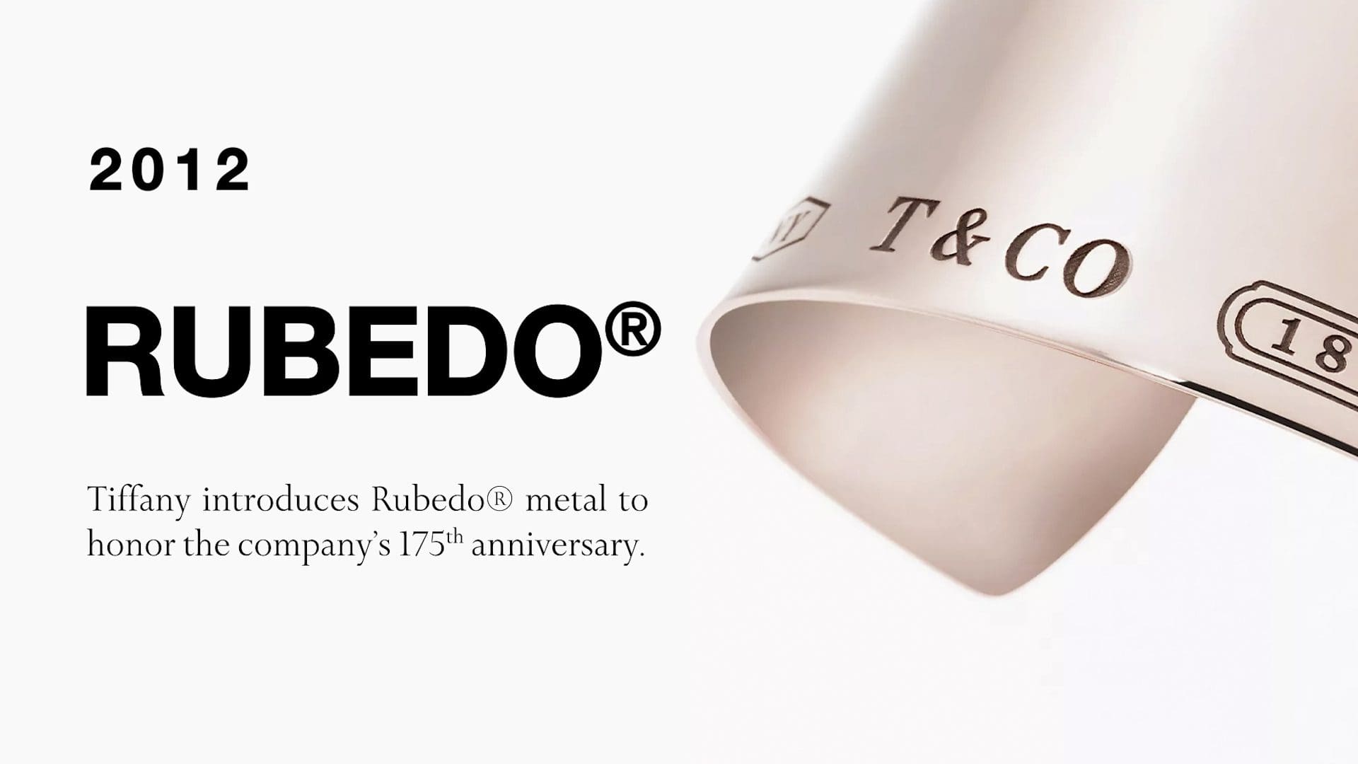 Promotional image for Tiffany & Co. from 2012, announcing the introduction of Rubedo® metal in honor of the company's 175th anniversary, featuring a curved sheet of the metal with Tiffany's branding.