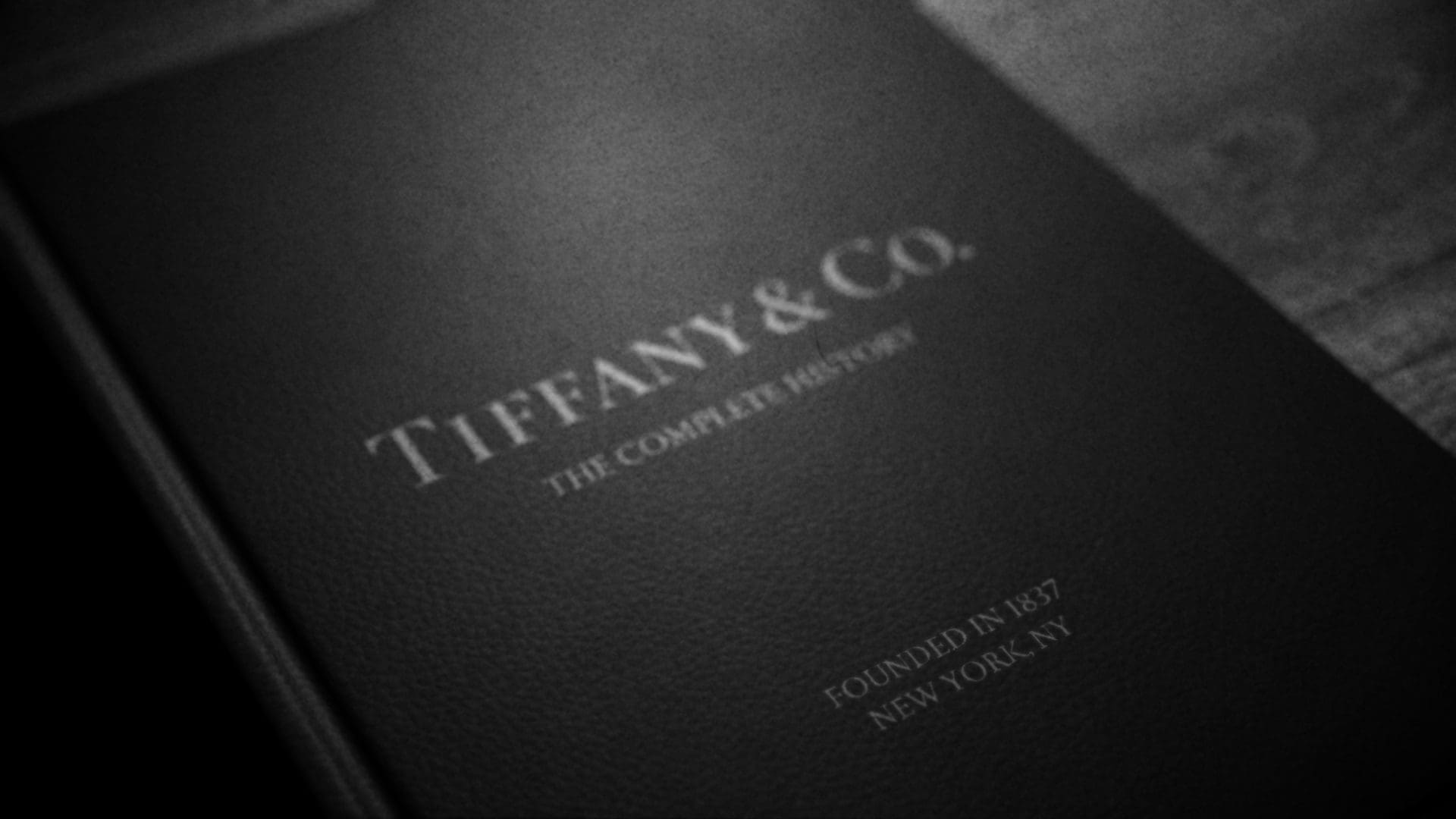 Close-up of a Tiffany & Co. book cover with the title 'The Complete History,' highlighting the founding year 1837 and location New York, NY.