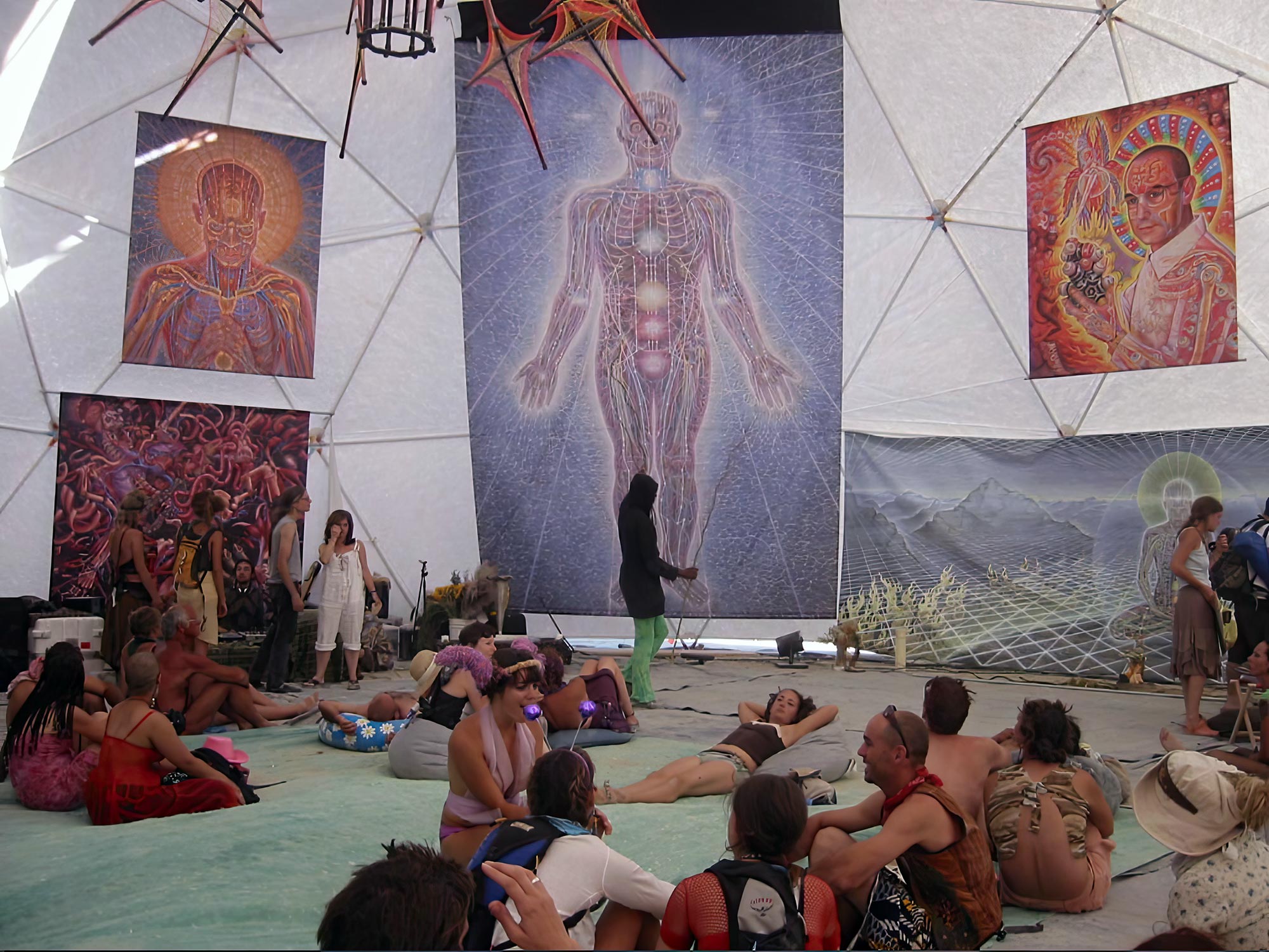 Participants gather at COSM beneath Alex Gray’s visionary artwork, exploring consciousness and spirituality.