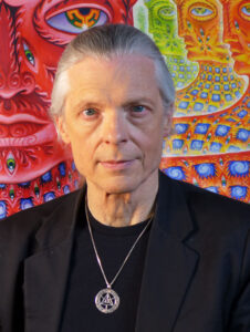 Alex Grey art portrait with his visionary artwork in the background.