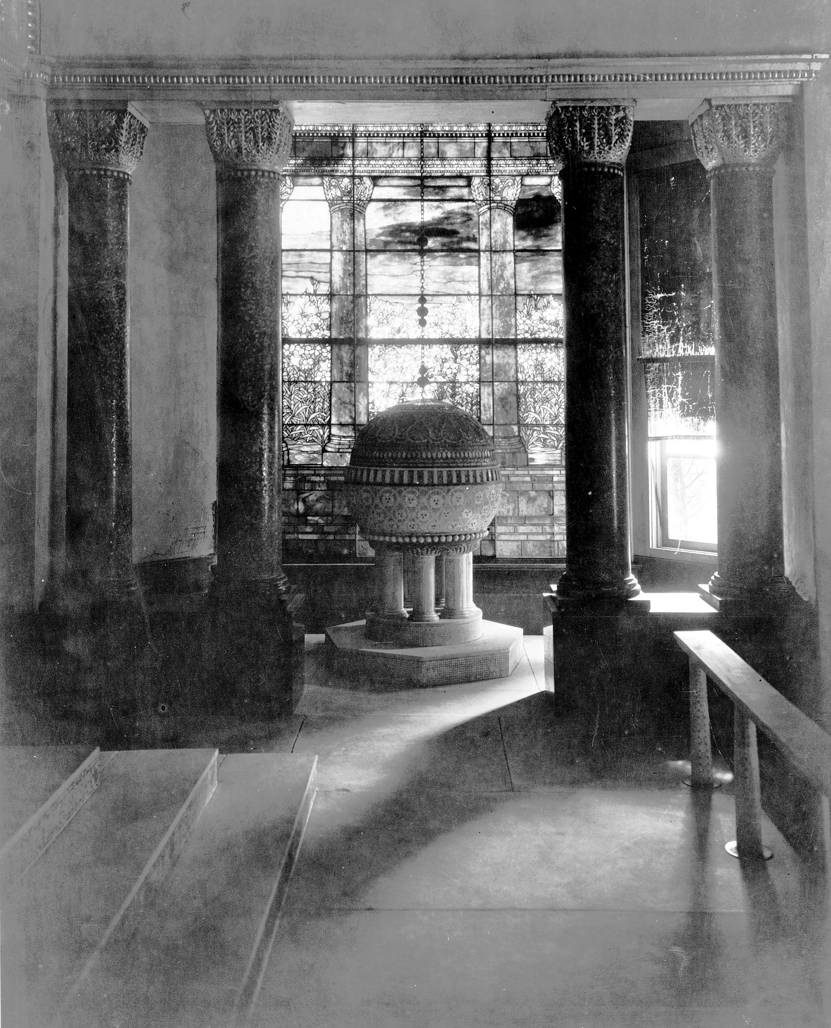 Tiffany Chapel interior, featuring intricate stained glass, mosaic details, and Byzantine-inspired columns. Photo via Wikimedia Commons.